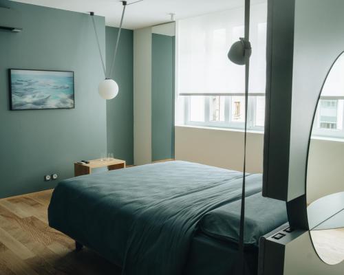 a bedroom with a bed with blue walls and a window at Mafrica House in Aosta