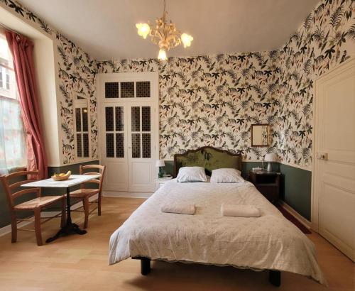 a bedroom with a bed and a table with chairs at 13 Bohemian Bienvenue B&B in Pontrieux