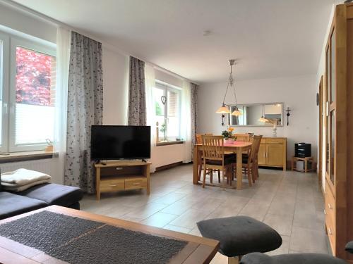 a living room with a television and a dining room at Frey - Ferienhaus über zwei Etagen mit Terrasse in Eggebek