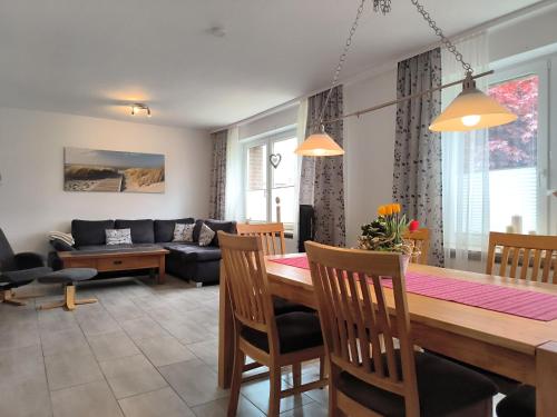 a dining room and living room with a table and chairs at Frey - Ferienhaus über zwei Etagen mit Terrasse in Eggebek