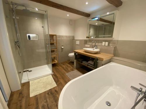 a bathroom with a tub and a shower and a sink at Haus Dekostüble in Münstertal