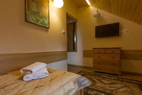a bedroom with a bed with towels on it at Pensjonat Adria in Zakopane
