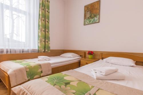 a room with two beds and a window at Pensjonat Adria in Zakopane
