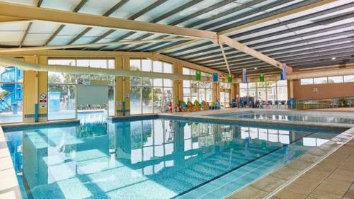 a large swimming pool in a large building at Jackson Home from Home Holidays in Little Clacton