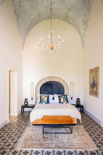 a bedroom with a large bed and a chandelier at Palazzo Saetta in Nardò