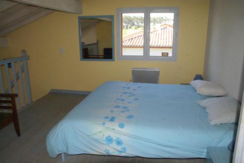 a bedroom with a large bed with blueberries on it at Maison sous les arbres in Lit-et-Mixe