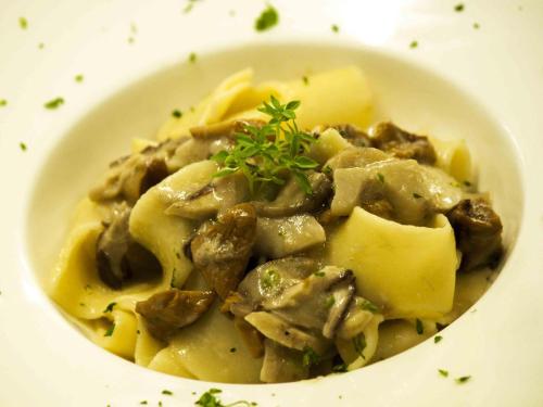 a white bowl of food with meat and cheese at Giorgio e Flora Ristorante e Locanda in Arsiero