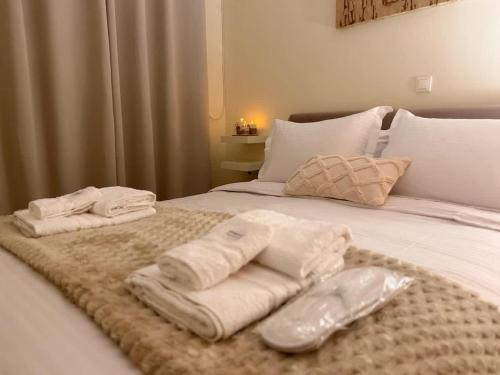 a bed with towels on top of it at ALIO Seaside Maisonette, Steps from Diakopto Beach in Diakopto