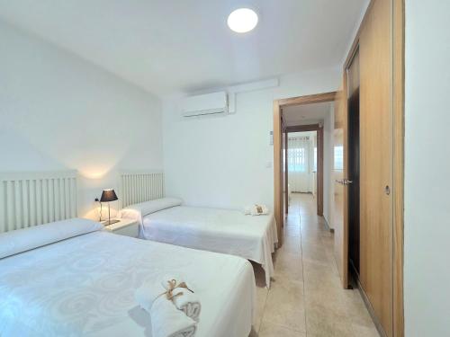 a hotel room with two beds and a hallway at HomeHolidaysRentals Lorraine - Costa Barcelona in Malgrat de Mar