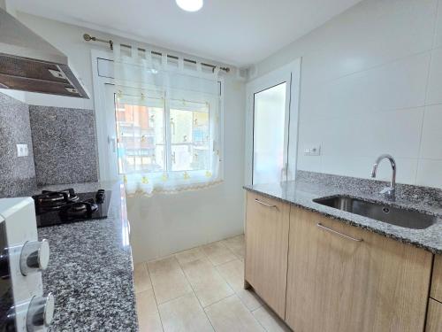 a kitchen with a sink and a window at HomeHolidaysRentals Lorraine - Costa Barcelona in Malgrat de Mar