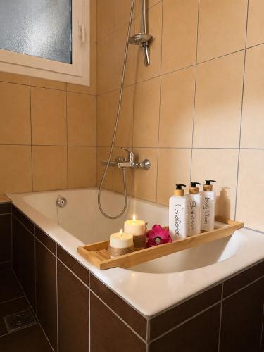 a bathroom with a bath tub with candles on it at ALIO Seaside Maisonette, Steps from Diakopto Beach in Diakopto
