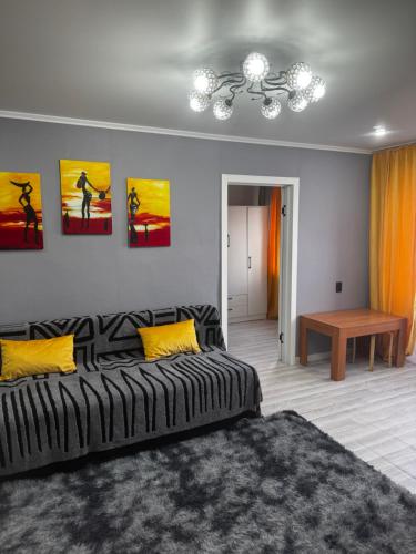 a bedroom with a bed and paintings on the wall at Квартира 1 линия in Balqash