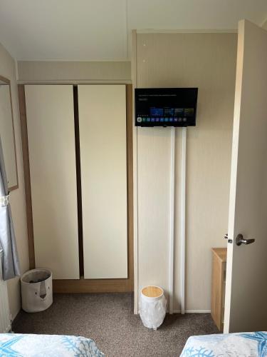 a room with two beds and a television on the wall at Bang Tidy 261 - Cabin - Wifi - Pool - Sleep 6 in Paignton