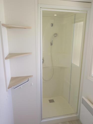 a shower with a glass door in a bathroom at Séjour à litteau in Litteau