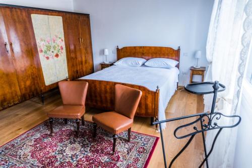 a bedroom with a bed and two chairs at Agriturismo Dai Gobbi in Fara Vicentino