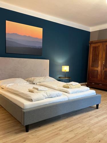 a large bed in a bedroom with a blue wall at Ferienwohnung in Reichenau an der Rax in Reichenau