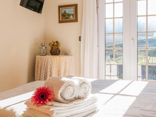 a pile of towels on a bed with a window at Quinta da Padrela Winery House in Tabuaço