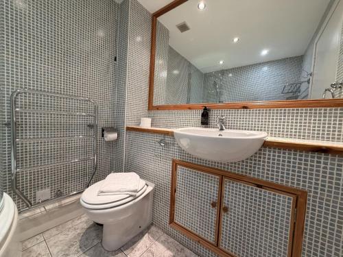 a bathroom with a toilet and a sink at Loch Leven Hotel & Distillery in Glencoe