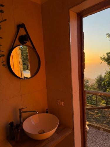 a bathroom with a round mirror and a sink at Habitat Eco Farm in Sorrento