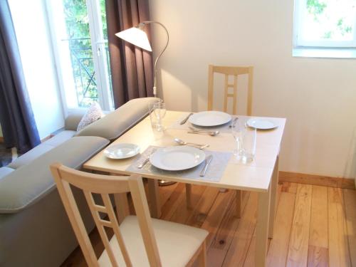 une table de salle à manger avec des assiettes et des verres dessus dans l'établissement Le Rosier, à Segonzac