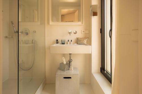 a bathroom with a sink and a shower at 9Hotel Sablon in Brussels