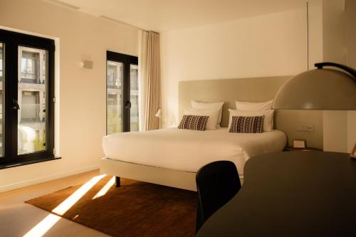 a bedroom with a white bed and a window at 9Hotel Sablon in Brussels