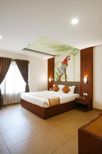 a bedroom with a bed with a painting on the wall at Clay House in Trichūr