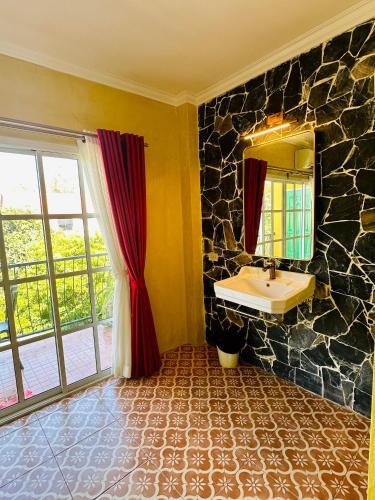 a bathroom with a sink and a stone wall at The Castello Resort in Ko Larn