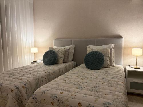 a bedroom with two beds with pillows and two lamps at Odivelas Home in Odivelas