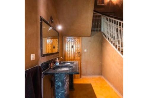 a bathroom with a sink and a mirror at Gite Tamlli in Aoufous