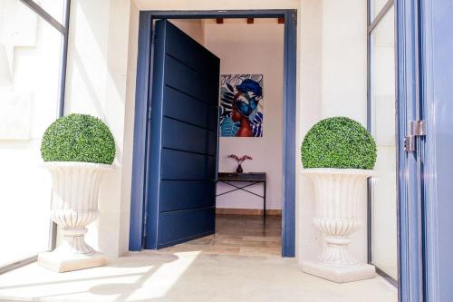 a blue door in a hallway with two white vases at Finca cataleya in Noez