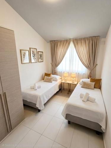 a hotel room with two beds and a window at Kristal Paris Resort in Novalja