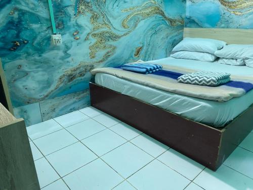 a bed in a room with a painting on the wall at Wind Stay in Male City