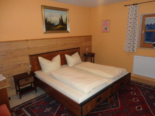 Schlafzimmer mit einem Bett mit weißer Bettwäsche in der Unterkunft Jägerhäusl in Arrach
