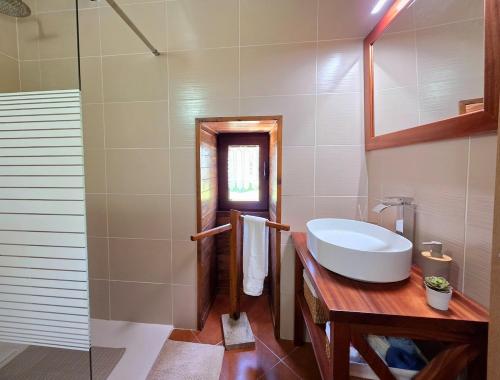 a bathroom with a tub and a sink and a mirror at Casa da Covinha - Branda da Aveleira in Melgaço