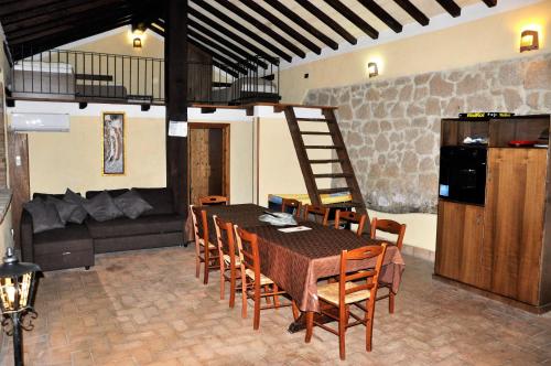 a dining room with a table and chairs and a couch at Agriturismo Nociquerceto in Tarano