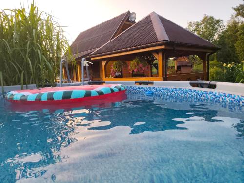 a swimming pool in front of a gazebo at Chrzanowa Dolina in Maruny