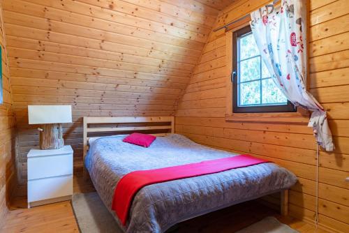a bedroom with a bed in a log cabin at Chrzanowa Dolina in Maruny