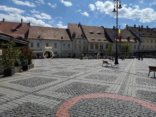 a cobblestone plaza in a city with buildings at Vista Rustic Room in Sibiu