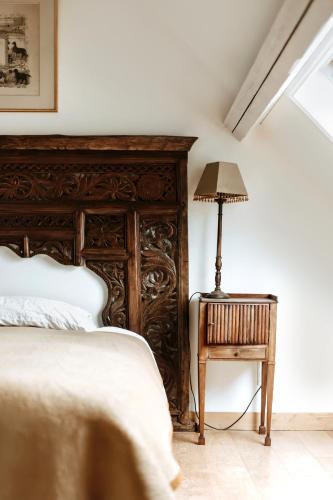 a bedroom with a bed and a table with a lamp at Haras de Baudemont in Ittre