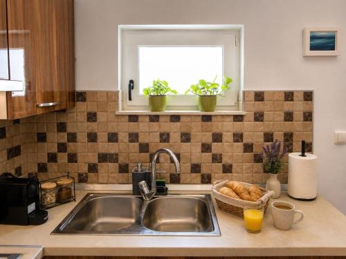 a kitchen counter with a sink and a window at Apartment Near Zadar Airport & City in Crno