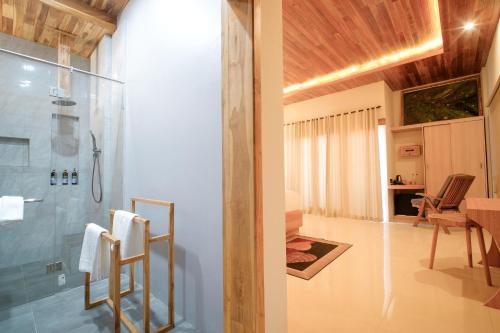 a bathroom with a shower and a room with a table at Giri Rose Boutique Hotel in Kuta Lombok