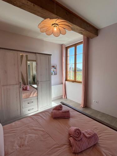 a bedroom with a large bed with two towels on it at Les Blancs - Maison de maître entourée de vignes in Lisle-sur-Tarn