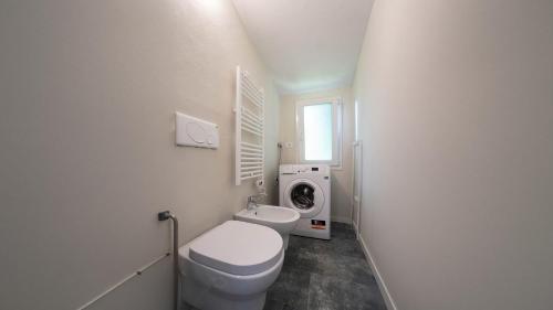 a bathroom with a toilet and a washing machine at Casa del Falegname - Loft Abete con cucina in San Giovanni in Bosco