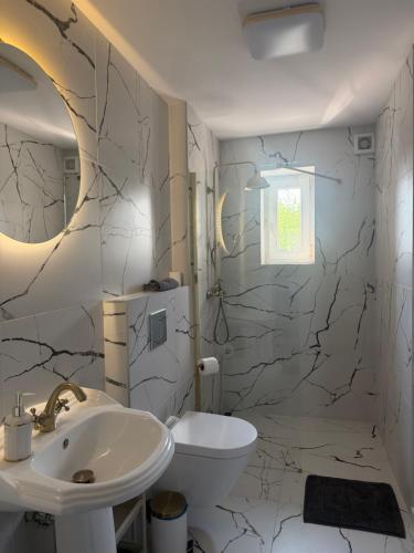 a bathroom with a sink and a toilet at Brickller Apartments by Letrent in Żyrardów