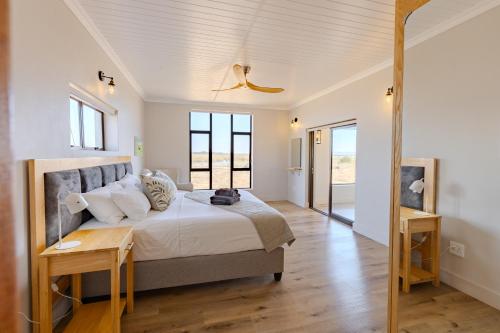 a bedroom with a large bed with a wooden floor at Quagga River Lodge in Velddrif