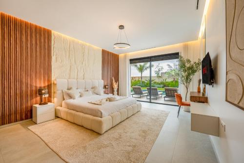 a bedroom with a large white bed and a large window at Villa Gaspard - Piscine et jardin Privée Sans vis-à-vis Wifi HD in Marrakesh