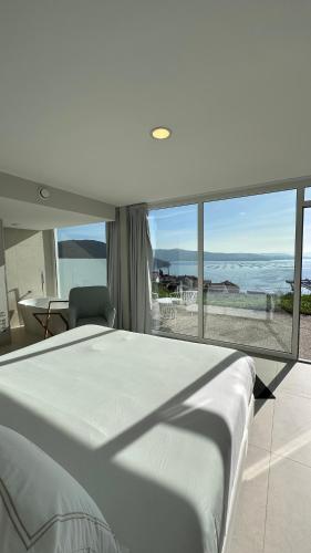 a bedroom with a bed and a view of the ocean at Otantus Hotel in Muros