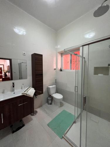 a bathroom with a toilet and a sink and a shower at Casa Tolentino in Bissau