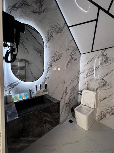 a bathroom with a sink and a toilet and a mirror at Quba QubaLand in Qǝlǝduz